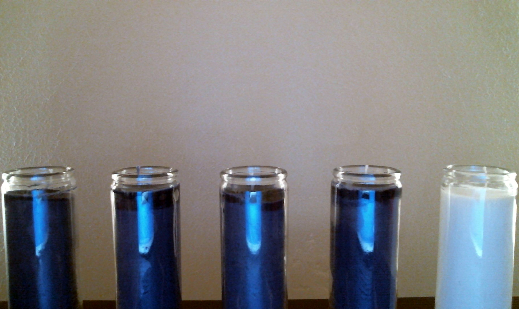 Four purple candles and one white candle. None are lit.